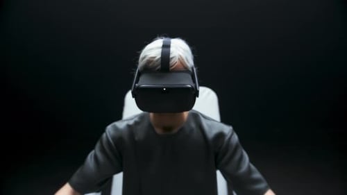 Person in VR Headset Sitting in Futuristic Chair
