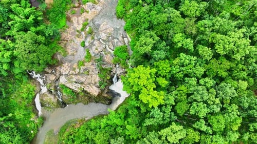Aerial view: Stunning waterfall in lush tropical forest.