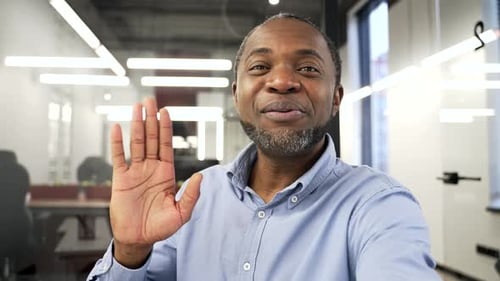 POV Happy african american businessman talking on a video call using a phone in business office.