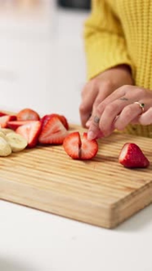Cut, strawberry and hands of woman in kitchen with healthy meal for detox, diet and nutrition