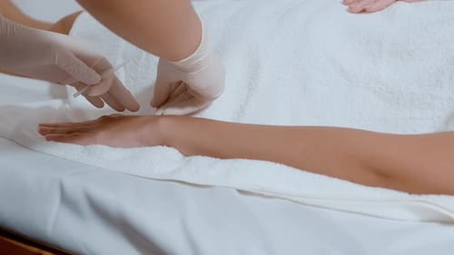 Hermosa mujer recibió un tratamiento de acupuntura en la mano por un terapeuta