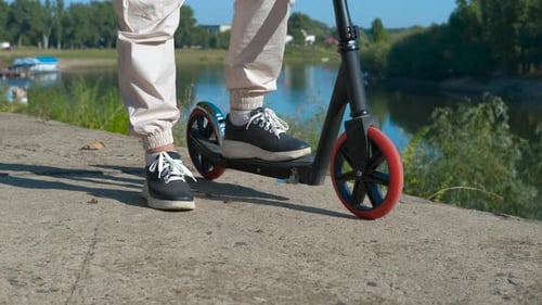 Teenager with Scooter Near River