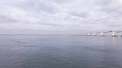 bird's eye view low over the water of the Oosterschelde next to the huge Zeeland bridge in the Nethe