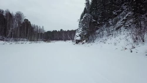 Un paysage hivernal époustouflant avec une rivière enneigée traversant une forêt sereine