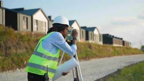 Surveyor Using Theodolite Equipment at Construction Site
