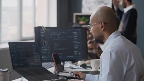 Indian Male Programmer Coding on Computers during Lunch Break in Office