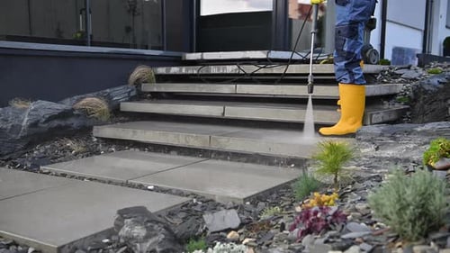Men Washing His Backyard Garden Concrete Path and Stairs Using Pressure Washer