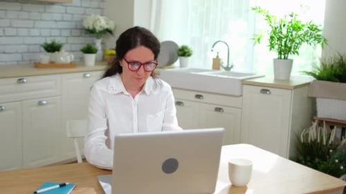 Woman Works on Laptop in Bright Airy Kitchen