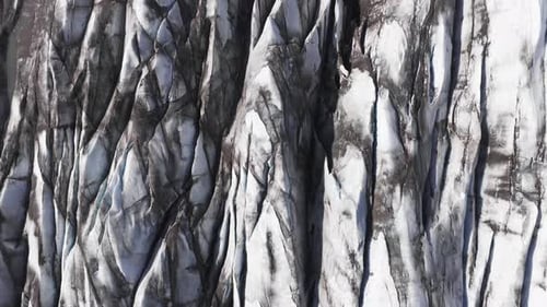Luftaufnahme des Gletschers mit dunklem Sediment und hellem Eis in Island