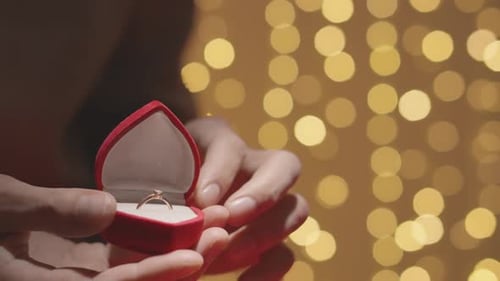 Closeup of Hands Opening a Red Box for Wedding Ring and Jewelry