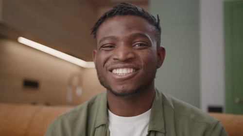 Man Smiles at Camera Indoors