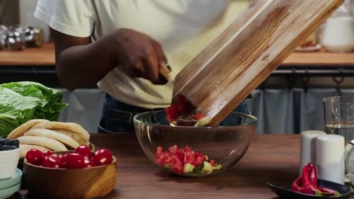 Woman Prepares Fresh Salad in Bright Home Kitchen
