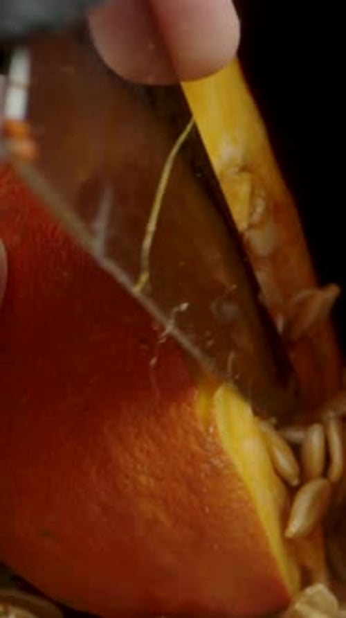 Vertical video. The camera zooms in on the halved pumpkin, and I retrieve the stuck knife from it.