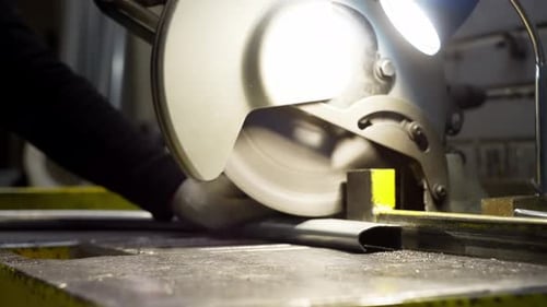 Engineer Operating a Metal Saw to Cut Steel Structures in an Industrial Factory