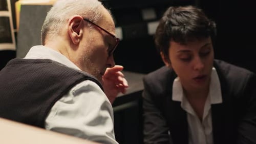 Businesspeople Discuss Information on Tablet in Office