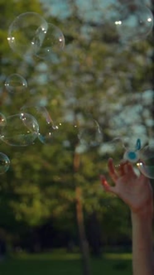 Woman Blowing Bubbles Outdoors in the Sun