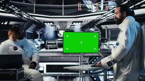 Researchers Flying Together in Starship Looking at Green Screen Monitor