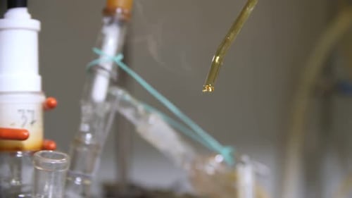 Gloved Hand Using Pipette in Science Lab