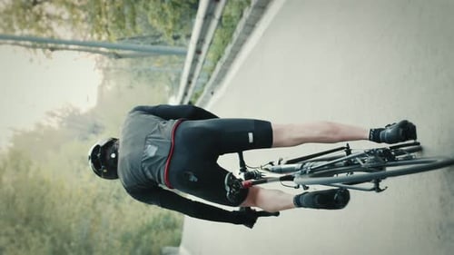 Cyclist Riding Up Empty Road in Countryside
