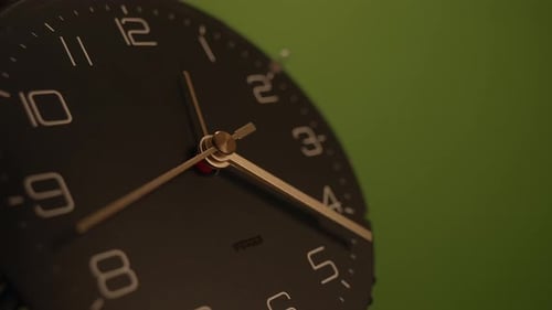 This is a Modern Wall Clock Showcased Beautifully Against a Vibrant Green Background