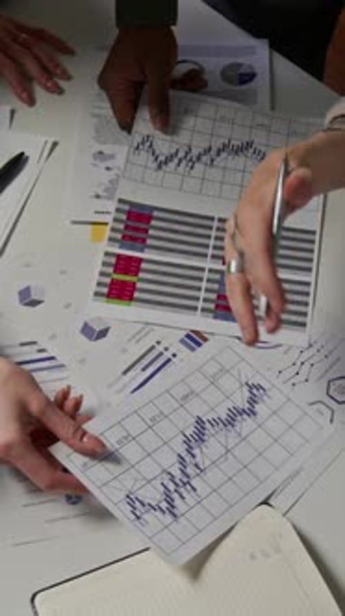 Unrecognizable Specialists Working With Charts And Graphs