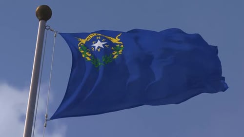 Nevada State Flag Waving Proudly Against Blue Sky