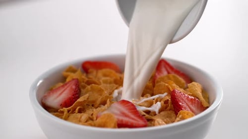 Pouring Milk on Cereal with Strawberries