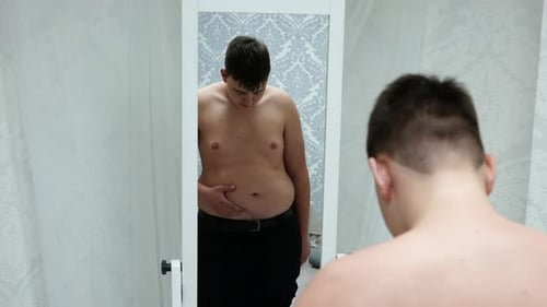 Individual Looks at Their Body in the Mirror