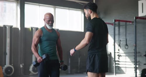 Mature man, personal trainer and weightlifting in gym for exercise, workout or training