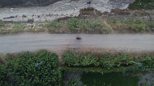 Aerial view of vehicles driving on a road crossing the Limboto Lake