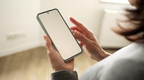Woman's hands holding a smartphone with blank screen