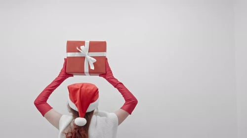 Woman in Santa Hat Holding Christmas Present