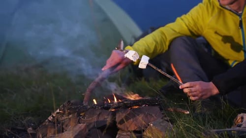 Preparing marshmallows from campfire. Majestic Carpathian Mountains. Beautiful landscape
