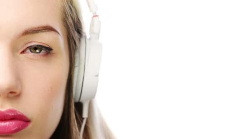 4k video footage of a young woman using headphones against a white studio background