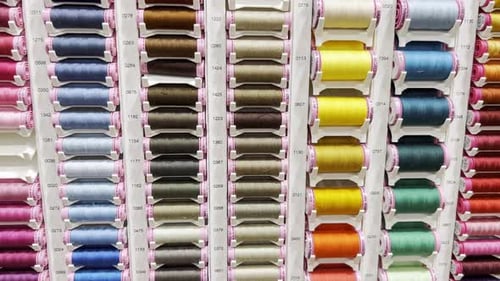 Many Threads of Different Colors Placed on Racks in the Workshop of a Clothing Atelier