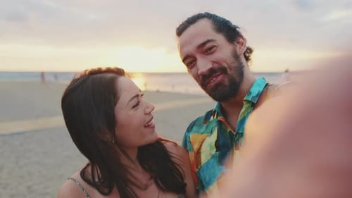Happy couple taking selfie while standing on the beach