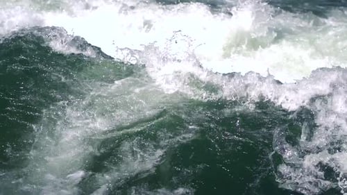 Wild waves at a fast rapids. Cold icy Eisbach in munich closeup. Brave people surf here in all seaso
