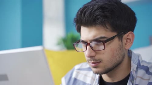 Young Adult Working on Laptop at Home