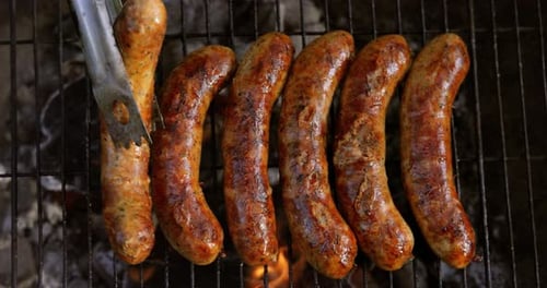 Delicious juicy sausages, cooked on the grill with a fire.
