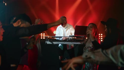 Energetic Crowd Dancing to DJ in Nightclub