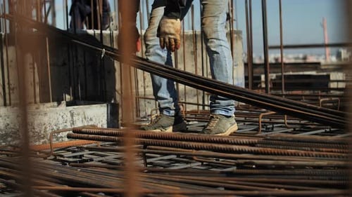 Bauarbeiter platziert Stahlbewehrung auf der Baustelle