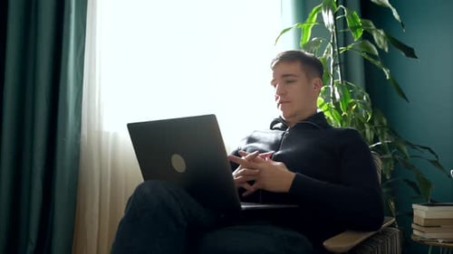 Man Using Laptop for Video Chat at Home