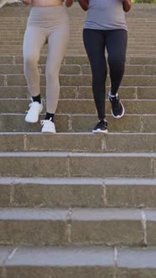 Two People Jogging Down Concrete Steps