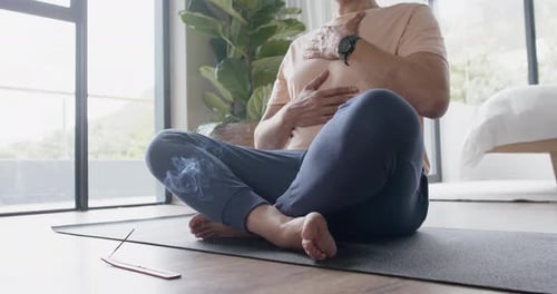 Senior man practicing yoga meditation at home
