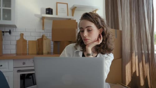 Woman Completes Task for Work Via Laptop Sitting at Table