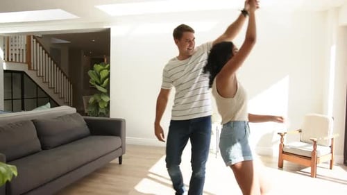 Cheerful Couple Dancing Together at Home on Sunny Day