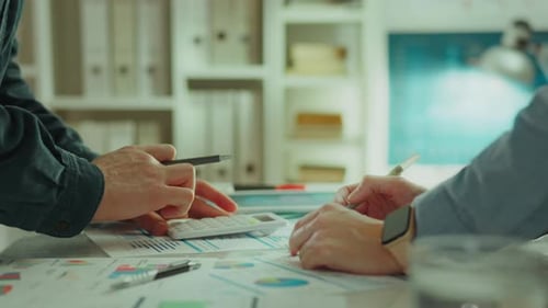 Team Reviewing Charts with Calculator in Bright Workplace
