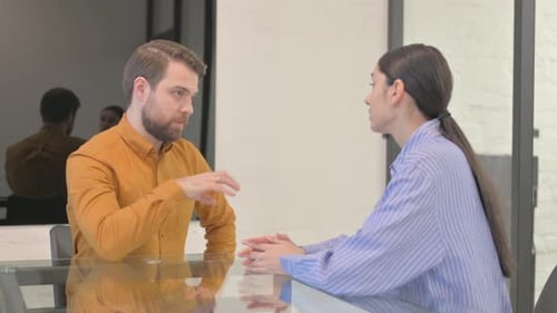 Glückliche Geschäftsleute gemischter Abstammung, die im Büro sprechen