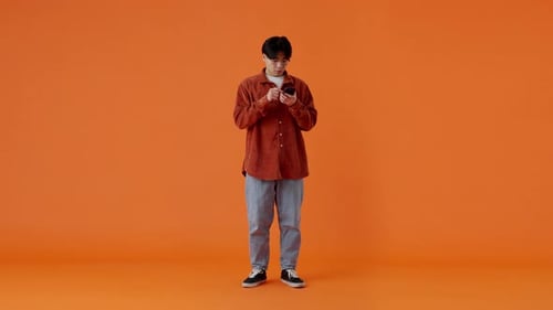 Man Celebrates Good News on Smartphone in Studio