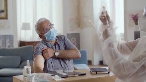 Ärztin bereitet eine Covid-Injektion für Patienten zu Hause vor